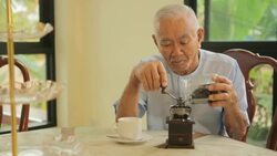 Asian senior man with vintage coffee grinder Stock Footage