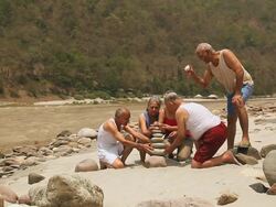 Five senior people playing at riverbank, Ganges River, Rishikesh, Uttarakhand, India Stock Footage