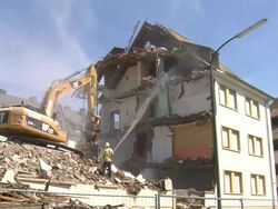 WS Demolition of apartment block and man watering / Saarburg, Rhineland-Palatinate, Germany Stock Footage