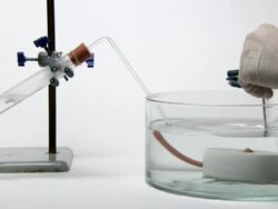 Collection of hydrogen gas. Chemist setting up a water-filled test tube for the collection of hydrogen gas. The gas is produced by the action of hydrochloric acid on magnesium metal in the test tube at left Stock Footage