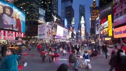 Customers sit down to eat at small tables underneath the neon lights and billboards of Times Square, New York. Stock Footage