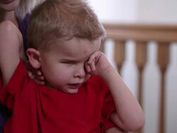 Medium shot of woman holding a blind child in her lap. Stock Footage