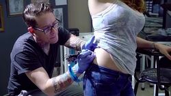 Woman receiving hip tattoo from tattoo artist Stock Footage
