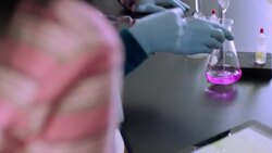 Teacher assists students using tablet to conduct lab Stock Footage