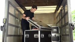 Crew member loads equipment into Flightcase in Truck Stock Footage