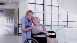 Portrait of smiling nurse comforting patient in wheelchair Stock Footage