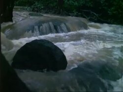 Waterfall, MCU muddy waterfall, pans right.  Panama. Stock Footage