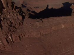 High Angle aerial - Sandstone rock formations cast long shadows over a desert valley / Grand Canyon Stock Footage