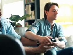 Friends on sofa playing Games Console Stock Footage