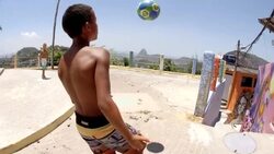 Young Brazilian boy kicks and heads soccer ball in slow motion overlooking Rio Stock Footage