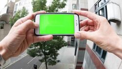 Man holding smartphone with green screen, pretending to do a video call. Stock Footage