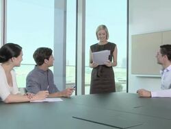 Businesswoman handing document to colleagues which they discuss Stock Footage