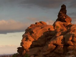 Unusual red rock spire with dramatic skies and morning light and shadows Stock Footage
