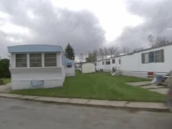 Medium Long Shot tracking-left - Cumulonimbus clouds loom behind a trailer park. /  Stock Footage