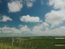 Time lapse blue sky clouds over green fields Stock Footage