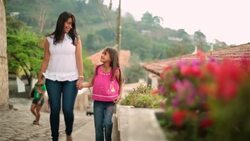 Young hispanic girl and older sister walk and talk hand-in-hand Stock Footage