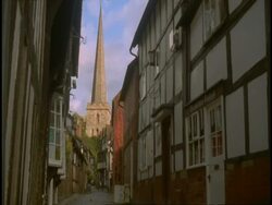 Old Tudor Buildings, Ledbury, Herefordshire - houses in narrow street, church spire at end of street Stock Footage