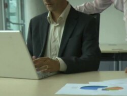 Man and woman looking at laptop and having conversation; UK Stock Footage