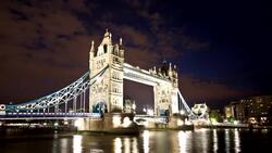 Lights reflect on the River Thames as traffic travels across Tower Bridge in London, England. Stock Footage