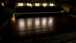 A basketball player dribbles across a darkened court and dunks the ball. Stock Footage