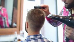 Hairdresser makes hairstyle with hairdryer bearded hipsters Stock Footage