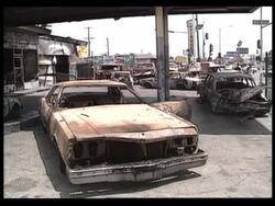 1992 MONTAGE WS TS Burned buildings and cars along streets in aftermath of LA riots / Los Angeles, California, USA Stock Footage