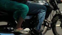 Girl in blue dress clutches bike while speeding through Rio traffic on mototaxi Stock Footage