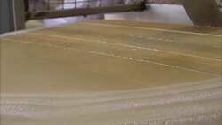 A machine slices cheese at a food-processing plant in Bern, Switzerland. Stock Footage