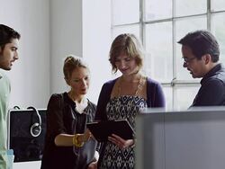 MS businesswoman standing holding digital tablet in discussion with coworkers in high tech office Stock Footage
