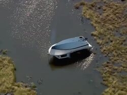 Aerial overturned fishing boat in shallow flood water / New Orleans, Louisiana Stock Footage