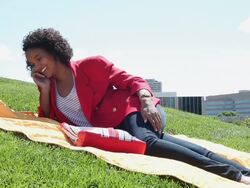 MS Young girl using cellular device outside in park on sunny day while lying on blanket / Minneapolis, Minnesota, United States Stock Footage