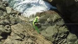 Man traverses highline stretched above sea below Stock Footage