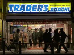 MS Shot of manga comic shop in Tokyo with pedestrians and traffic passing in front of it at night / Tokyo, Japan Stock Footage