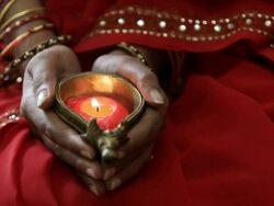 CU  Woman holding bronze candle holder with red candle in hand / Singapore Stock Footage
