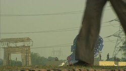 Pedestrians pass a giant blue statue in India. Stock Footage