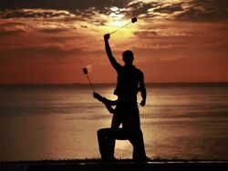 MS Sihouetted couple perform poi dance together with fireballs in front of fiery sunrise and ocean / Montezuma, Costa Rica Stock Footage