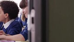 Students reading digital tablets and laughing in classroom Stock Footage
