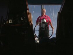 MS Older man looking out to sea from behind steering wheel of his sail boat / Wismar, Mecklenburg-Vorpommern, Germany Stock Footage
