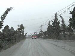 Truck drives through village coated in thick layer of volcanic ash mud from eruption of Merapi; Indonesia. 7 November 2010 / AUDIO Stock Footage