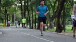 joggers, bicyclists on bike path road in Central Park Stock Footage