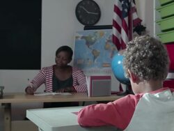 HD: Little Boy doing his work in front of Teacher Stock Footage