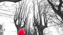 Girl with red heart shaped balloons waiting in park Stock Footage