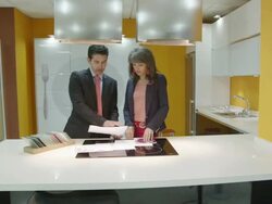 TS WS salesman and female client looking at plans and samples in a kitchen showroom showing modern furniture Stock Footage