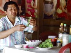 MS SLO MO Shot of Man in restaurant sitting at table and eating / Nong Khio, Luang Prabang, Laos Stock Footage