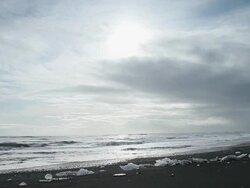 WS Many melting glaciers on black sand beach and sea waves rolling / Iceland  Stock Footage