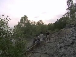 WS PAN Men digging mud on riverbank and building  retaining wall / India Stock Footage