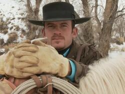 TU Cowboy stands behind horse dressed in western saddle / Shell, Wyoming, United States Stock Footage