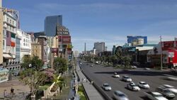 Traffic moves past illuminated hotels and casinos along the Strip in Las Vegas at night. Stock Footage