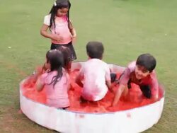 Group of kids playing holi festival in a lawn  Stock Footage