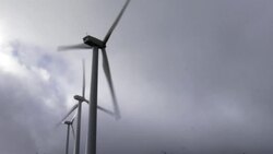 Wind turbines spin against a cloudy sky in North Dakota. Stock Footage